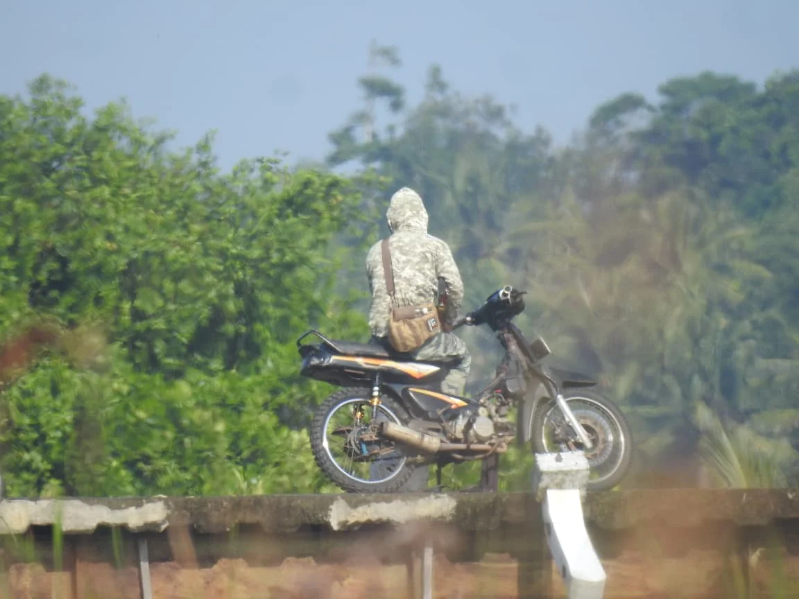 Salah seorang diduga pemburu sedang berada di jembatan dengan senapan anginnya untuk memantau satwa buruan Foto Hammam -...