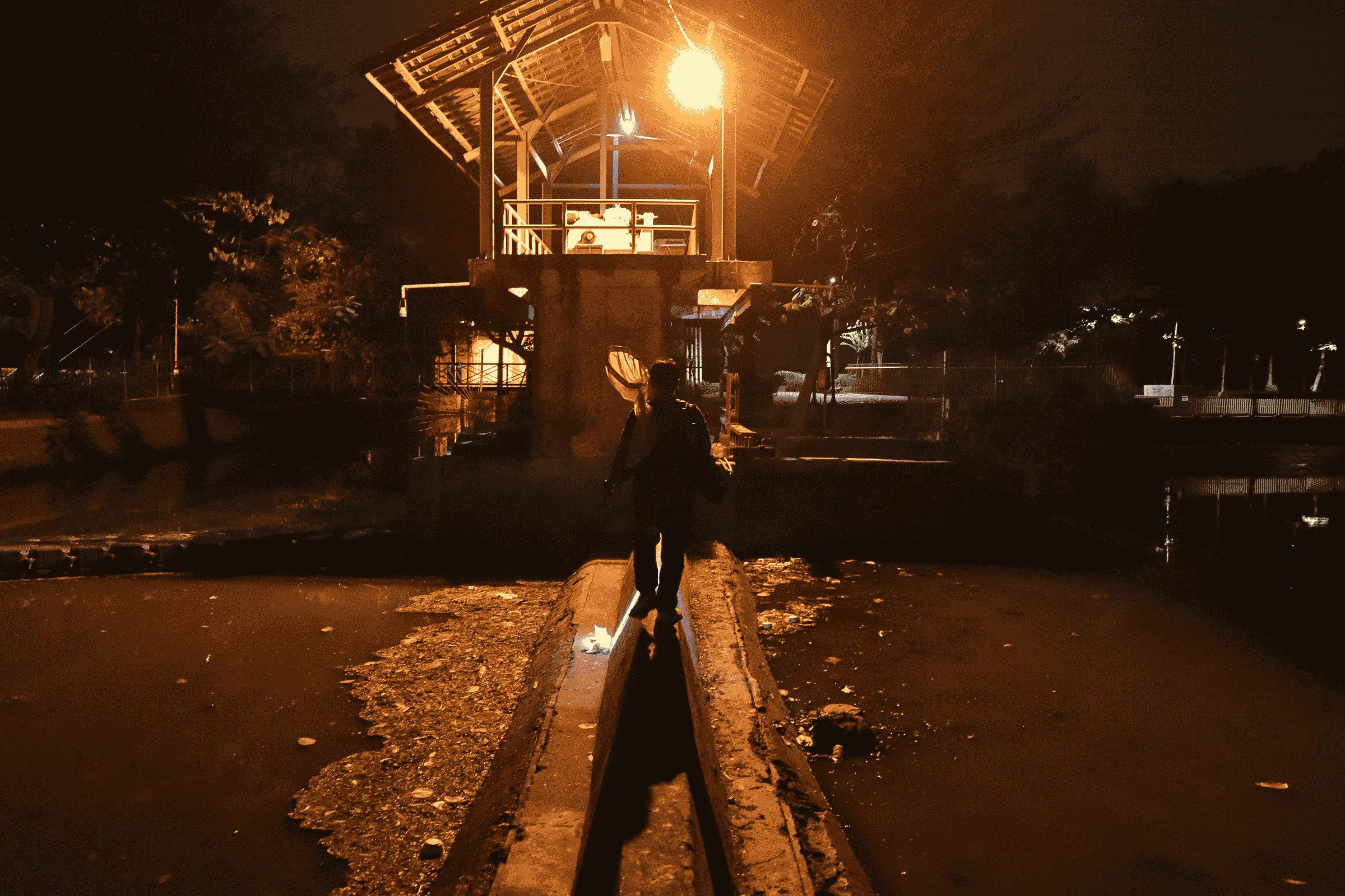 Bubu kadang dipasang di titik yang sulit dijangkau. Azriel harus menyeberangi bendungan sempit untuk mengambil bubu yang telah dipasang.